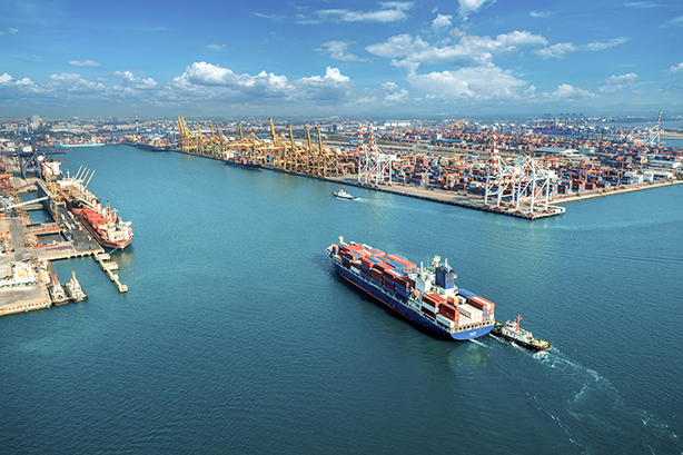 Aerial view of cargo ship and cargo container in harbor.